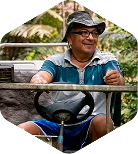 Homem idoso em cima de máquina sorrindo de forma distraída